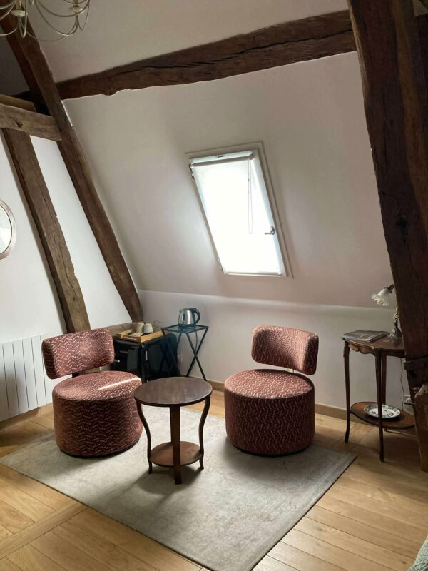 photo de deux chaises, une table et un frigo dans la chambre Sinople